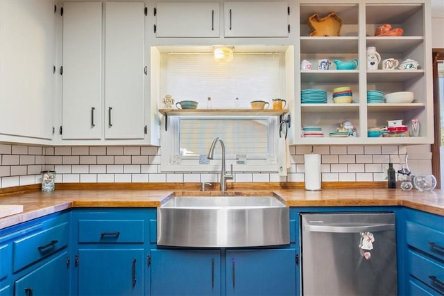 kitchen featuring blue cabinetry, butcher block counters, sink, and stainless steel dishwasher