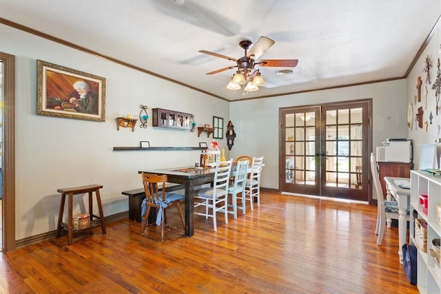 dining area with crown molding, ceiling fan, french doors, and hardwood / wood-style floors