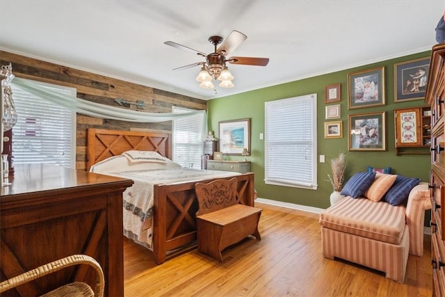 bedroom featuring ceiling fan, light hardwood / wood-style flooring, and crown molding