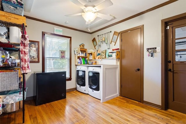 clothes washing area featuring ceiling fan, light wood-type flooring, ornamental molding, and washing machine and clothes dryer