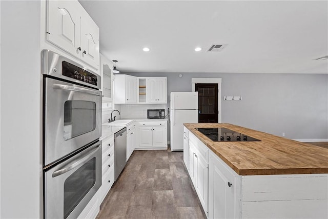 kitchen featuring wooden counters, sink, black appliances, dark hardwood / wood-style floors, and white cabinetry