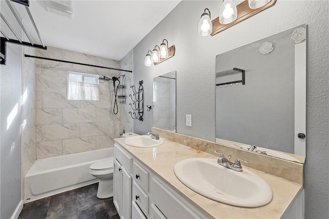 full bathroom with vanity, wood-type flooring, tiled shower / bath combo, and toilet