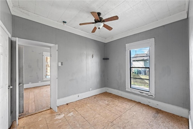 unfurnished room with ceiling fan and ornamental molding