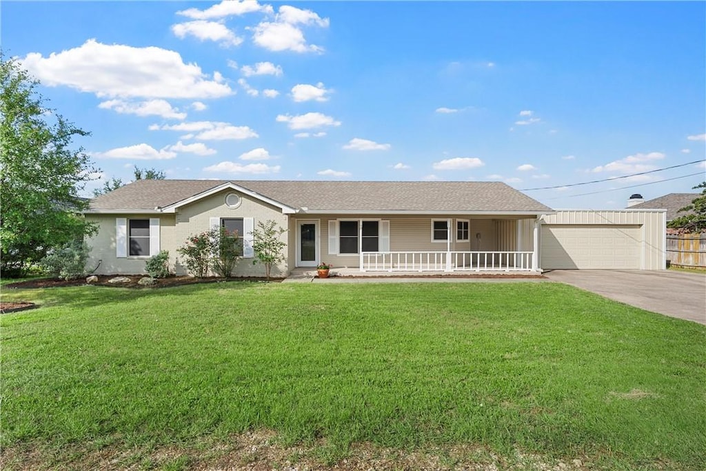 single story home featuring a front yard, a porch, and a garage