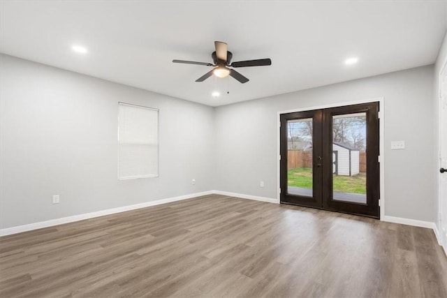 spare room with hardwood / wood-style floors, french doors, and ceiling fan