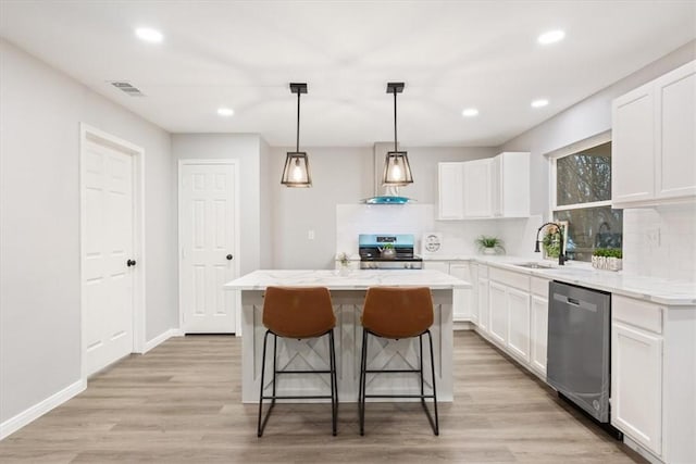 kitchen with white cabinetry, appliances with stainless steel finishes, a center island, and sink