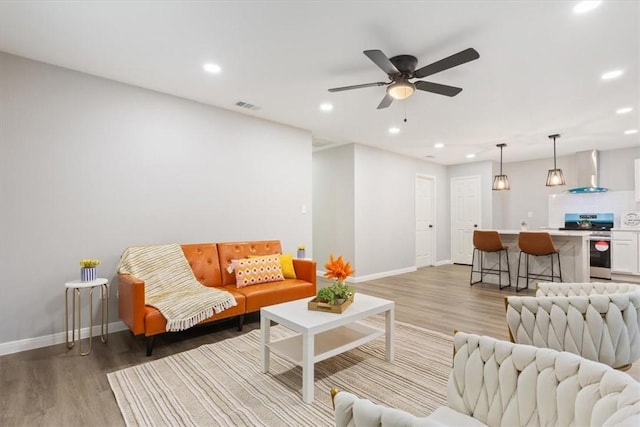 living room featuring wood-type flooring and ceiling fan