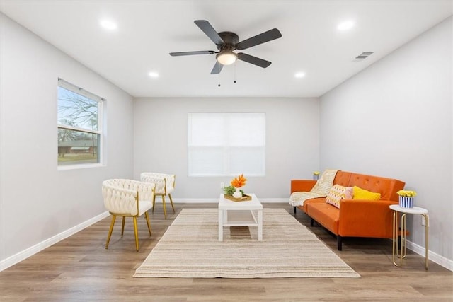 sitting room with hardwood / wood-style floors and ceiling fan