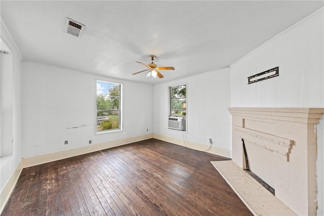 unfurnished living room with crown molding, a brick fireplace, dark hardwood / wood-style flooring, cooling unit, and ceiling fan