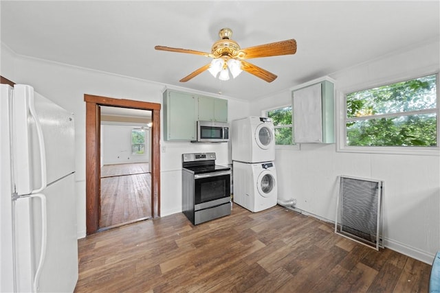 kitchen with stainless steel appliances, stacked washing maching and dryer, dark hardwood / wood-style floors, and ceiling fan