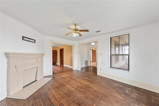 unfurnished living room featuring crown molding, ceiling fan, and dark hardwood / wood-style floors