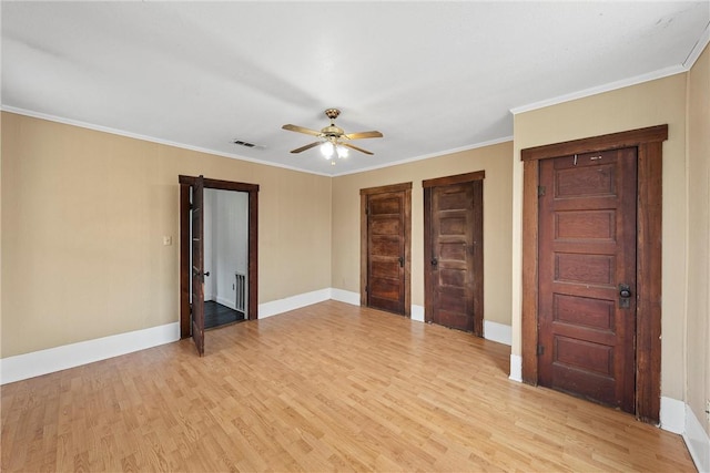 unfurnished bedroom with crown molding, ceiling fan, two closets, and light wood-type flooring