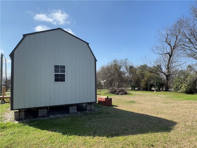 view of side of property with an outbuilding and a yard