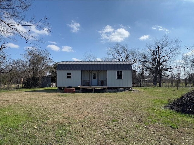 rear view of house featuring a lawn