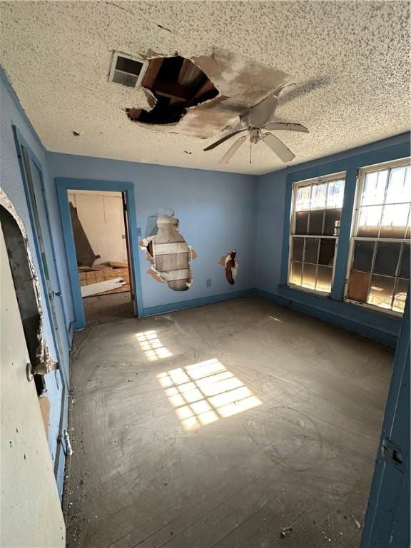 unfurnished room featuring ceiling fan and a textured ceiling