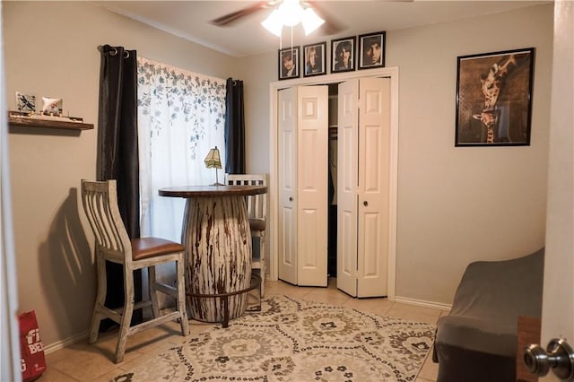 living area with ceiling fan and light tile patterned floors