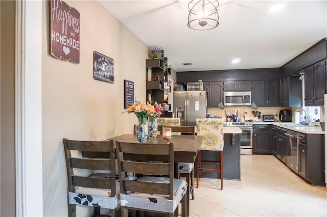 kitchen featuring pendant lighting, a breakfast bar, sink, and stainless steel appliances