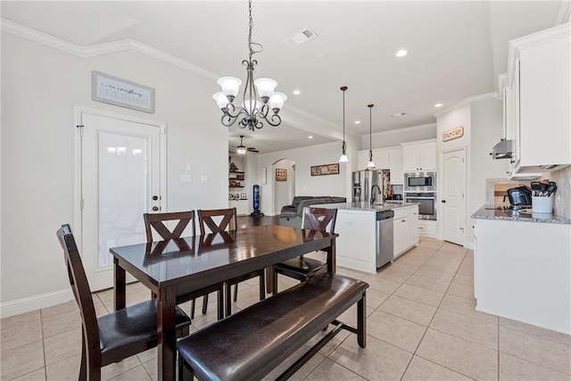 dining space featuring ceiling fan with notable chandelier, light tile patterned floors, crown molding, and sink