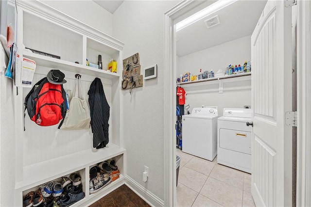 mudroom with light tile patterned flooring and separate washer and dryer