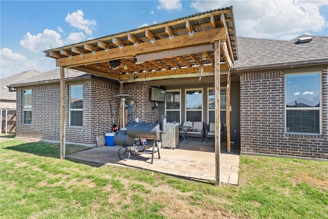 rear view of house featuring a pergola, a patio area, and a lawn