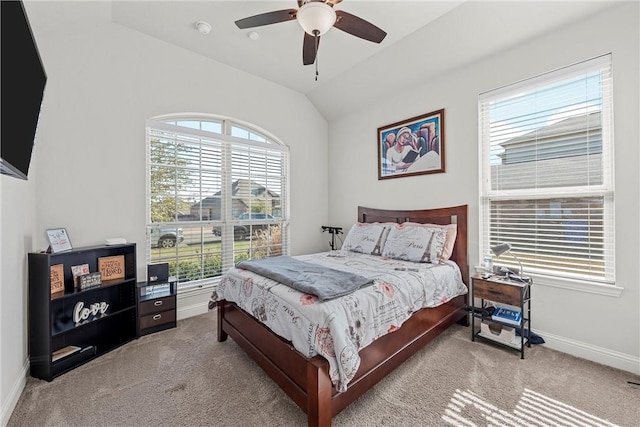 carpeted bedroom with ceiling fan and vaulted ceiling