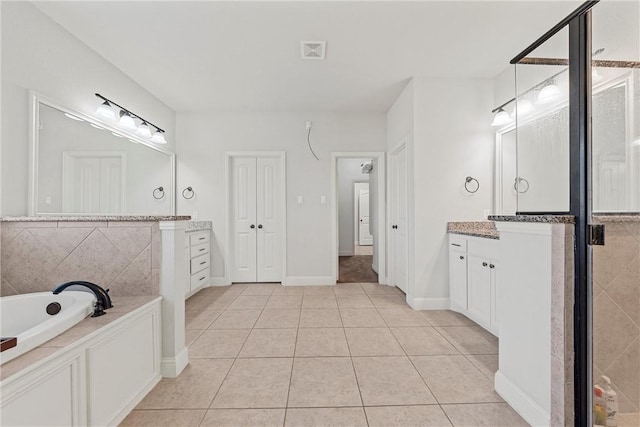 bathroom with vanity, tile patterned flooring, and a bath