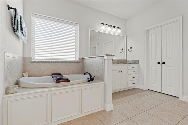 bathroom featuring tile patterned floors, a tub, and vanity