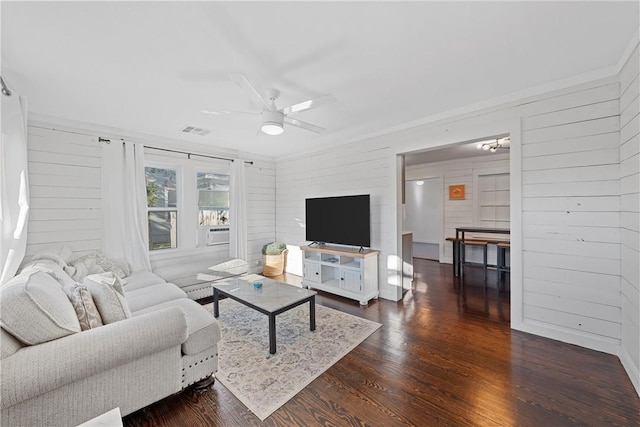 living room featuring dark hardwood / wood-style floors, ceiling fan, and wood walls