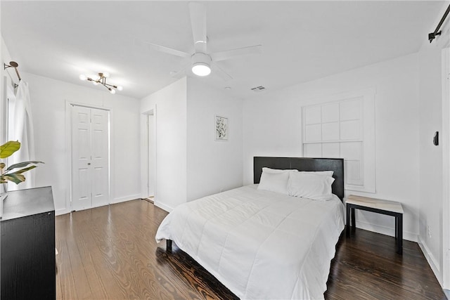 bedroom with ceiling fan, dark hardwood / wood-style flooring, and a closet