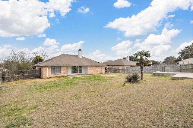 rear view of property with a yard and a patio area