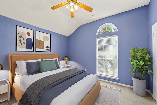 carpeted bedroom with ceiling fan and vaulted ceiling