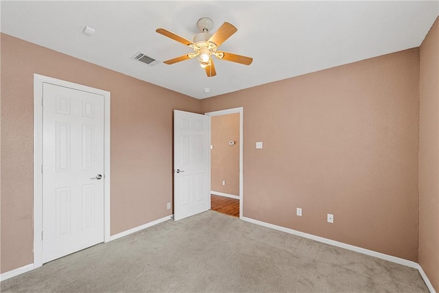 unfurnished bedroom featuring light colored carpet and ceiling fan