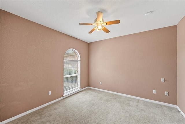 empty room with ceiling fan and light colored carpet