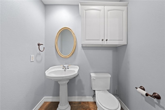 half bathroom with toilet and baseboards