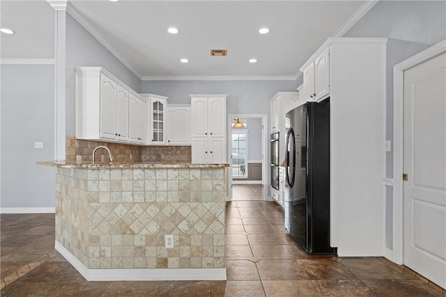 kitchen with visible vents, decorative backsplash, glass insert cabinets, freestanding refrigerator, and ornamental molding