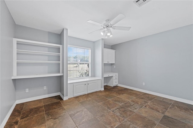 interior space with visible vents, baseboards, stone finish flooring, and built in study area