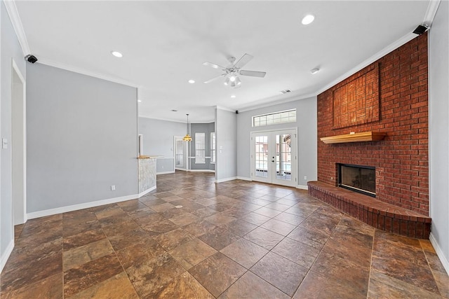 unfurnished living room featuring a brick fireplace, french doors, crown molding, and baseboards