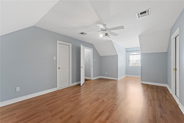 additional living space with light wood-type flooring, visible vents, and baseboards