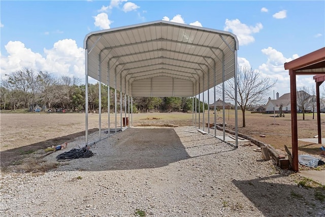 view of parking with driveway and a detached carport