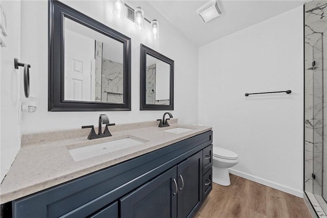 bathroom featuring a shower, vanity, hardwood / wood-style flooring, and toilet