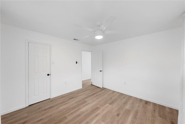 spare room with ceiling fan and light wood-type flooring