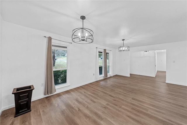 unfurnished living room featuring a chandelier and wood-type flooring