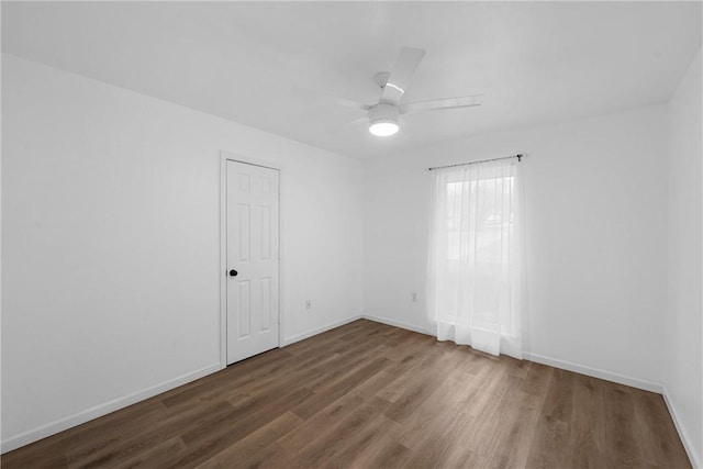 spare room with ceiling fan and dark hardwood / wood-style flooring