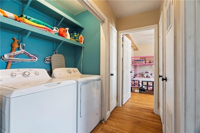 washroom featuring washer and clothes dryer and light hardwood / wood-style floors