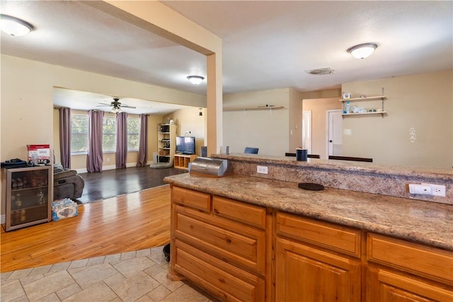 kitchen with light wood-type flooring and ceiling fan