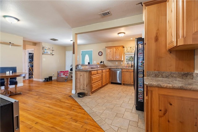 kitchen featuring a textured ceiling, stainless steel appliances, light hardwood / wood-style floors, and sink