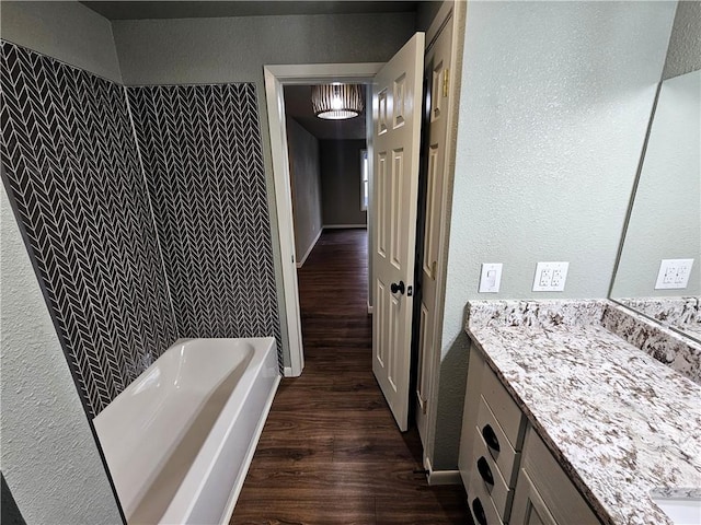 bathroom with vanity, a bathing tub, and hardwood / wood-style flooring