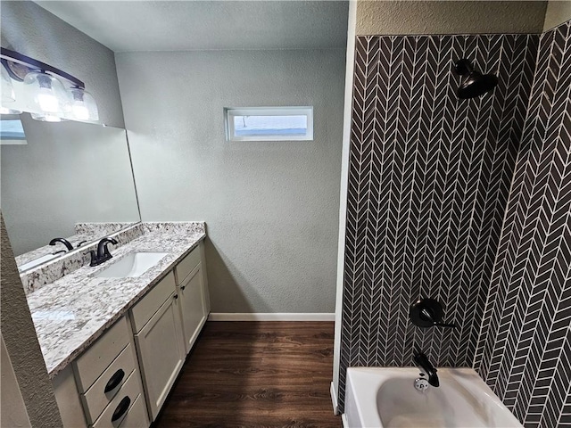 bathroom featuring hardwood / wood-style flooring, vanity, and bathing tub / shower combination