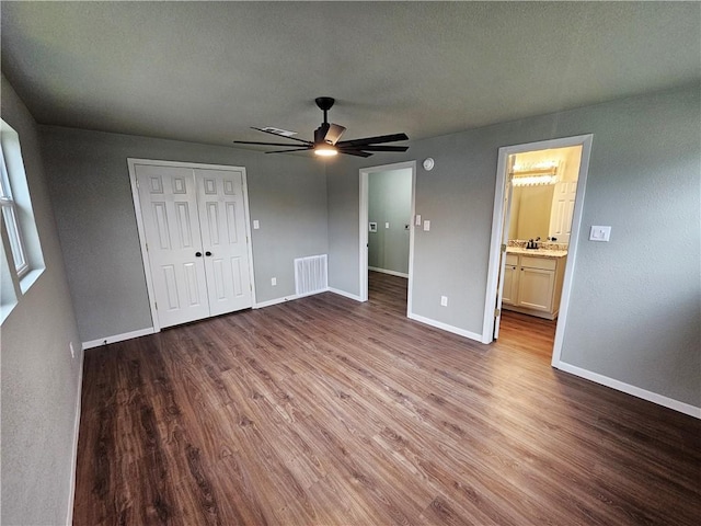 unfurnished bedroom with light wood-type flooring, ceiling fan, a textured ceiling, and ensuite bath