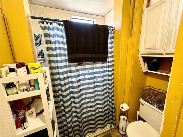 bathroom with a shower with shower curtain and toilet